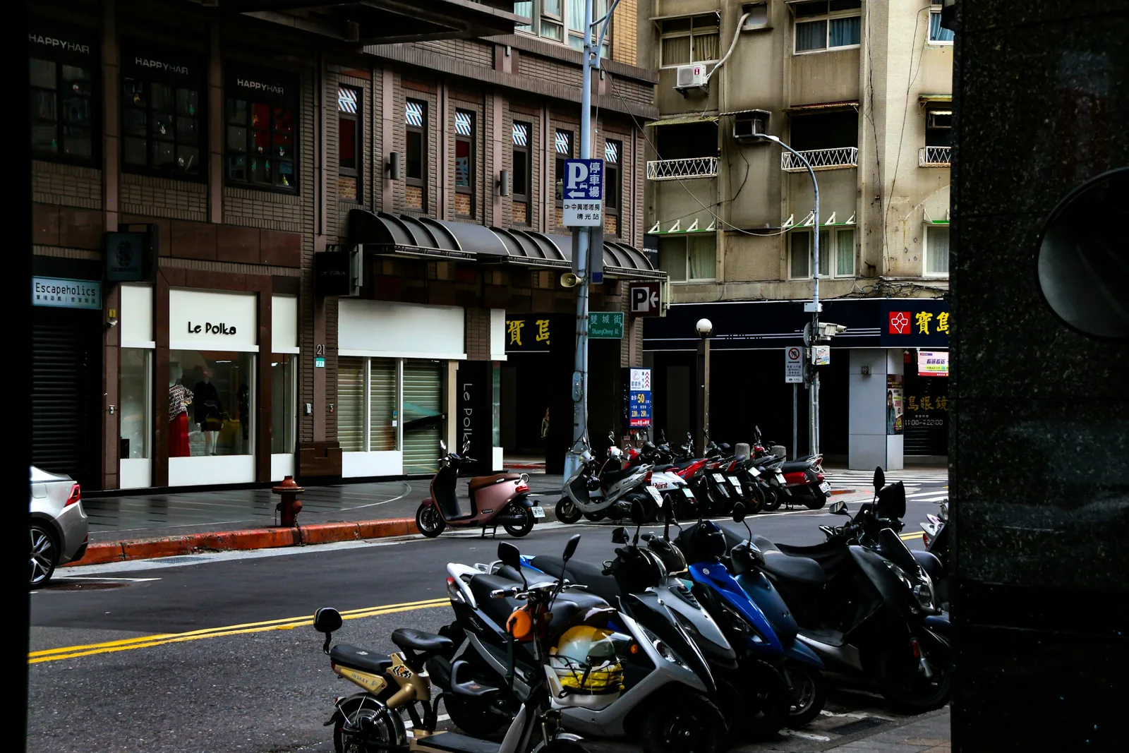 台北街邊騎樓前停放的一排機車